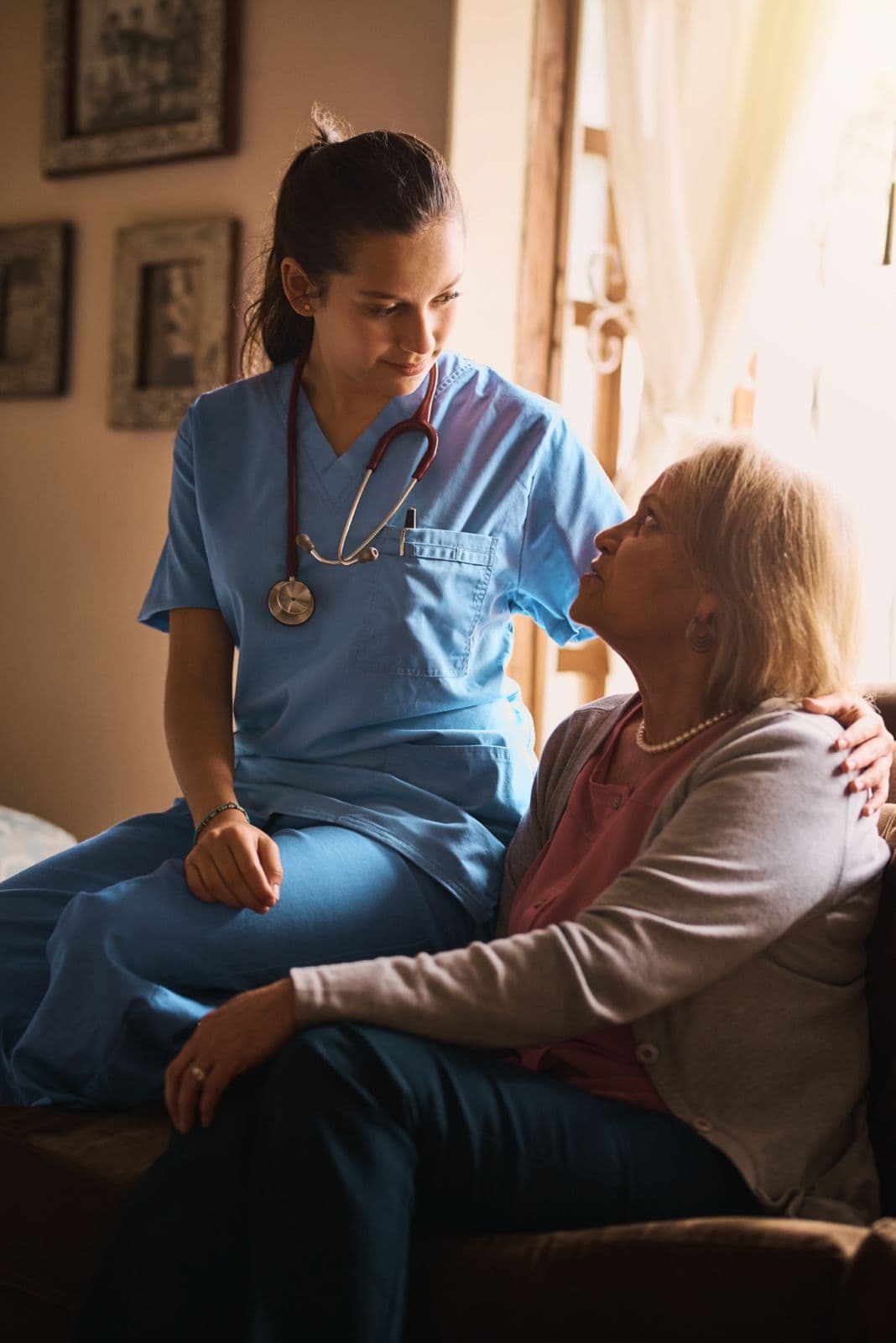 A nurse supporting an elderly patient at home